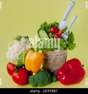 Bio Gemüse broccoli Gurken Paprika Äpfel in Braun aus Kraftpapier grocery Bag auf gelben Hintergrund. Gesunde Ernährung Ballaststoffe vegan Plas Stockfoto