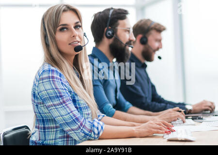 Junge Frau mit Kollegen, die im Büro der Call Center. Stockfoto