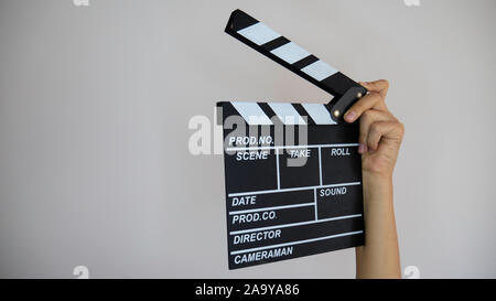 Nahaufnahme der weiblichen Beteiligung an der Hand classic Direktor klare Leer schwarz Film die Klappe auf hellgrauem Hintergrund isoliert. Stockfoto