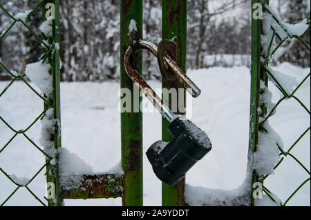 Schloss auf dem alten Zaun zu öffnen. Schnee Zaun. Stockfoto