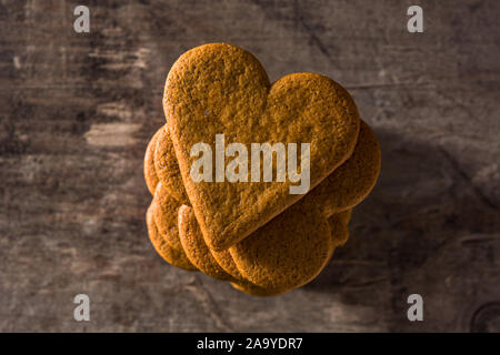 Herzförmige Plätzchen auf Holztisch. Valentinstag und Muttertag Konzept. Ansicht von Oben. Stockfoto