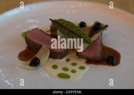 Fleisch Hauptgerichte vom Lamm Kotelett, schwarz, Knoblauch, Lauch, Buttermilch Dressing auf einer weißen Platte Stockfoto