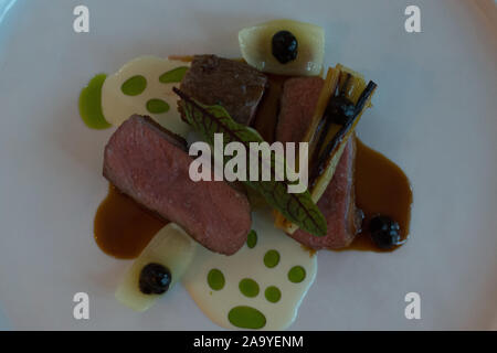 Fleisch Hauptgerichte vom Lamm Kotelett, schwarz, Knoblauch, Lauch, Buttermilch Dressing auf einer weißen Platte Stockfoto