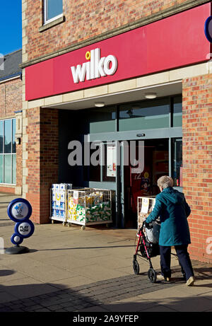 Ältere Dame vorbei gehen. Wilko store in Selby, North Yorkshire, England, Großbritannien Stockfoto