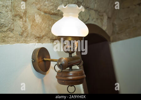 Stilvolle Lampe auf der Tapete. Wandleuchte aus vergoldetem Metall mit zwei elektrischen Kerzen. vintage Wandleuchte in Weiß mit Freistellungspfad isoliert. Warm Stockfoto