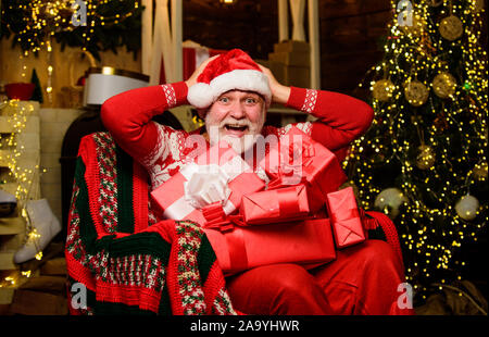 Aufregung. Frohes neues Jahr. Secret santa. Präsentiert von Santa. Winterurlaub Shopping. Party Feier. Geschenke am Weihnachtsbaum. Frohe Weihnachten. bärtiger Mann gehen einkaufen. Weihnachtsgeschenke. Stockfoto