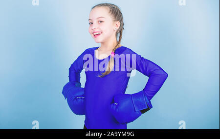 Glückliches Kind Sportsman in Boxhandschuhen. Training von kleinen Mädchen Boxer. Stanzen Knockout. Kindheit Aktivität. Fitness Ernährung. Energie Gesundheit. Sport Erfolg. sportswear Mode. Entspannung nach dem Training. Stockfoto