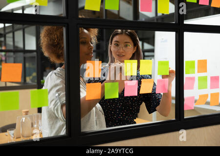 Afrikanische amerikanische Junge weibliche Scrum Master arbeiten mit vietnamesischen Kollegen. Stockfoto