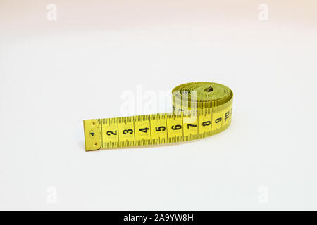 Gelbe Maßband in Meter und Zoll in einer Spirale Stockfoto