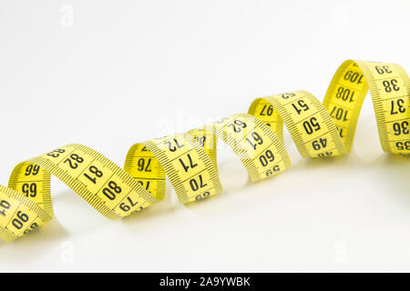 Gelbe Maßband in Meter und Zoll in einer Spirale Stockfoto