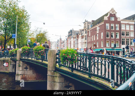 Amsterdam, Niederlande - 15.10.2019: Fahrräder auf einer Brücke über die Kanäle von Amsterdam. Bunte Häuser und Blumen. Herbst. Reisen. Stockfoto