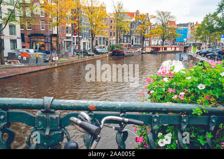 Amsterdam, Niederlande - 15.10.2019: Fahrräder auf einer Brücke über die Kanäle von Amsterdam. Bunte Häuser und Blumen. Herbst. Reisen. Stockfoto