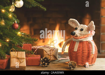 Weihnachten Zusammensetzung - ein Korb weiße Maus - Symbol von 2020 nach dem chinesischen Horoskop neben Geschenke unter dem Weihnachtsbaum im Zimmer von fir Stockfoto