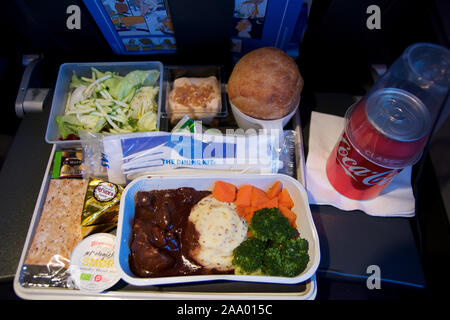 SAN FRANCISCO, California, United States - Jun 24th, 2018: warmes Essen an Bord der Economy Class Flugzeug am Tisch serviert mit Salat und Cola Stockfoto