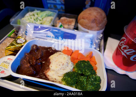 SAN FRANCISCO, California, United States - Jun 24th, 2018: warmes Essen an Bord der Economy Class Flugzeug am Tisch serviert mit Salat und Cola Stockfoto