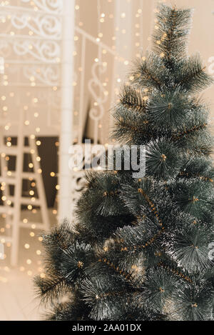 Künstlicher Weihnachtsbaum im hellen Innenraum des Hauses ohne Spielzeug. Schließen Baum mit künstliche Zweige. Stockfoto