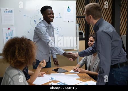 Lächelnd african american Young Leader Händeschütteln mit kaukasischen Kollegen. Stockfoto