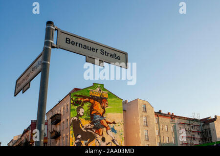 Zeichen Straße und Graffiti in einem Haus in der Nähe vom Mauerpark, Berlin im Abendlicht Deutschland. Willkommen in Belin, brasilianische Team. Joga Bonito. Mauerpa Stockfoto