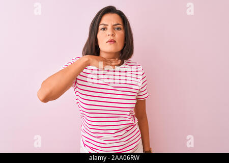 Junge schöne Frau in gestreiften T-Shirt stehend über isolierte rosa Hintergrund schneiden Kehle mit Hand als Messer, bedrohen Aggression mit Furio Stockfoto