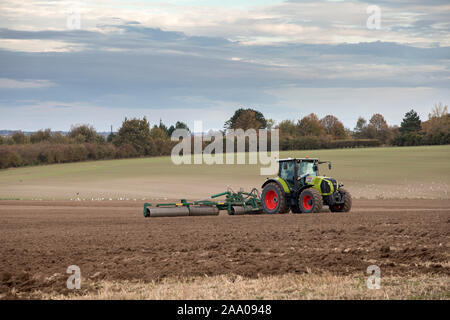 Traktor Pflüge Felder am Stadtrand von Cambridge mit Addenbrookes Krankenhaus in der Ferne Stockfoto