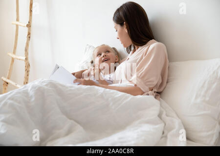 Glückliche Familie von zwei entspannende im Bett, Buch zu lesen. Stockfoto