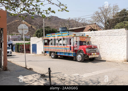 Eine bunte lokale Open Air Bus, auf einem vintage Ford Truck, an der Seite der Straße in Taganga, Santa Marta, Kolumbien geparkt auf Basis Stockfoto