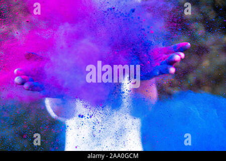 Junge Frau spielt mit Farben, die Schaffung einer Farbe Explosion mit Blau. Stockfoto