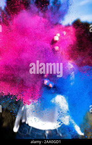 Junge Frau spielt mit Farben, die Schaffung einer Farbe Explosion mit Blau. Stockfoto