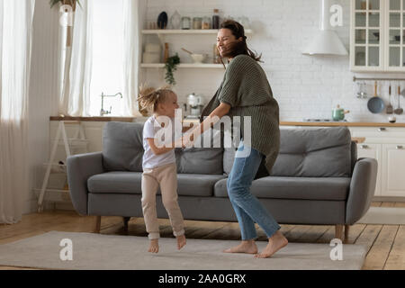 Glückliche kleine Vorschule kind Mädchen tanzen mit Mama. Stockfoto