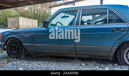 Alte blaue Auto steht auf dem Parkplatz. gebrochen Auto Stockfoto