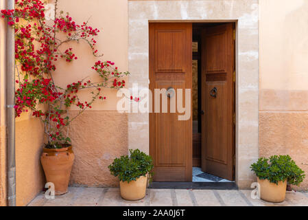 Spanische Haus mit Tür und Blumen auf der Straße in der schönen Altstadt von Alcudia. Balearen Architektur. der Insel Mallorca. Spanien Stockfoto