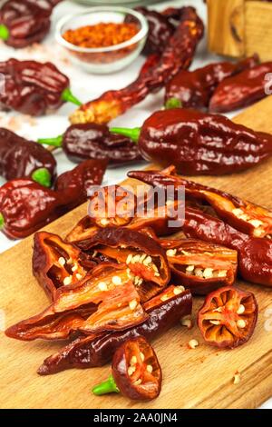 Schneiden extra hot chili peppers (Bhut Jolokia Chocolate). Vorbereitung für das Trocknen. Verkauf von Gewürzen. Gesunde Gewürze. Stockfoto