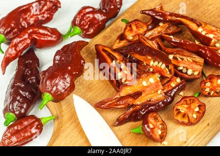 Schneiden extra hot chili peppers (Bhut Jolokia Chocolate). Vorbereitung für das Trocknen. Verkauf von Gewürzen. Gesunde Gewürze. Stockfoto