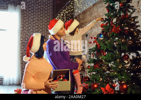 Glückliche Familie schmücken Weihnachtsbaum Stockfoto