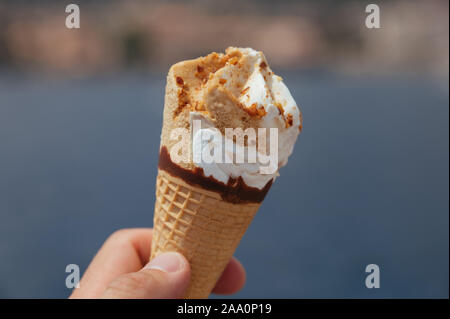 Eis in der Waffel Becher in der Hand des Mannes auf der Yacht Stockfoto