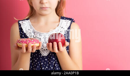 Ein Bild von einer Frau die Wahl zwischen Apple und Donut Stockfoto