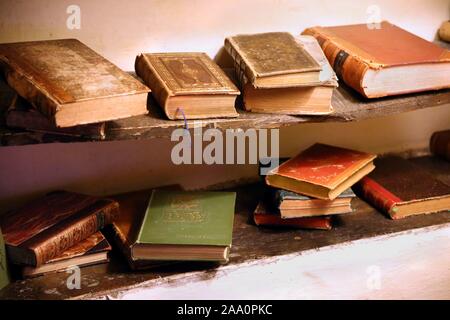 Keswick, Cumbria, Großbritannien - 6. April 2019: Auswahl an sehr alte antike Bücher, einige Leder gebunden, auf alten hölzernen Regalen Stockfoto