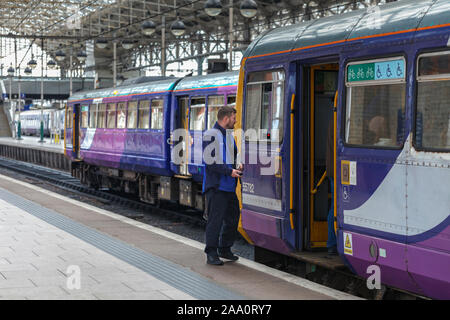 Train dispatcher mit 2 Arriva Northern Rail Class 142 pacer Züge am Bahnhof Manchester Piccadilly Stockfoto