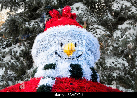 Fröhlicher Schneemann aus lametta auf dem Hintergrund einer Weihnachtsbaum im Schnee. Collage. Schneemann Charakter in das Neue Jahr Dekor und fest Stockfoto