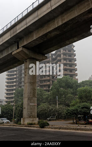 Das Verkehrsaufkommen durch und unten die schnelle U-Bahn Anschluss in Sektor 55 Gurgaon, die ungesunde Smog, die Auswirkungen auf die Gesundheit. Delhi Stockfoto