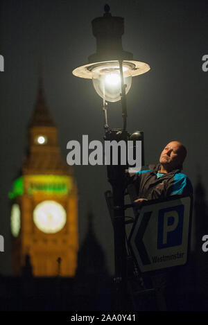 Eine von 1500 Gaslampen, die bleiben auf den Straßen von London von einem der fünf "lamplighters' von British Gas eingesetzt, die nach dem Lampen in Westminster Aussehen beibehalten wird. Stockfoto