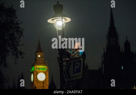 Eine von 1500 Gaslampen, die bleiben auf den Straßen von London von einem der fünf "lamplighters' von British Gas eingesetzt, die nach dem Lampen in Westminster Aussehen beibehalten wird. Stockfoto