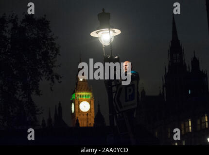 Eine von 1500 Gaslampen, die bleiben auf den Straßen von London von einem der fünf "lamplighters' von British Gas eingesetzt, die nach dem Lampen in Westminster Aussehen beibehalten wird. Stockfoto