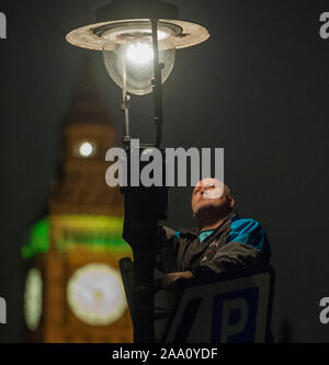 Eine von 1500 Gaslampen, die bleiben auf den Straßen von London von einem der fünf "lamplighters' von British Gas eingesetzt, die nach dem Lampen in Westminster Aussehen beibehalten wird. Stockfoto