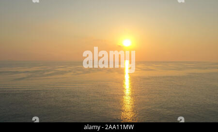 Luftbild mit drohne von einem farbenfrohen Sonnenaufgang über den Großen Ozean Meer mit schönen Reflexionslinie Stockfoto