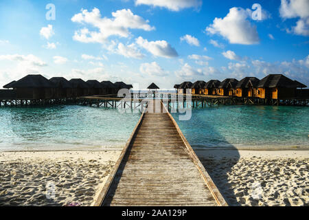 Holz- pfad Brücke zu den exotischen und luxuriöse Villa auf dem Wasser Bungalows auf dem Wasser auf hölzernen Säulen gemacht Stockfoto