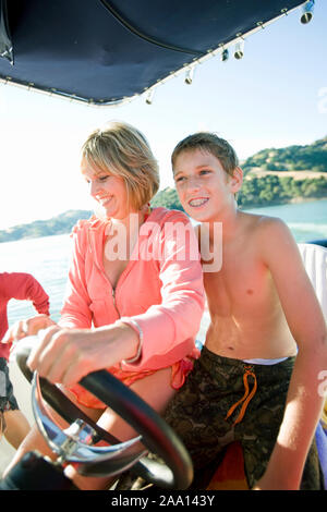 Mutter und Sohn Spaß beim Lenken ein Boot. Stockfoto