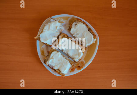 Brot mit saurer Sahne und Butter auf der Platte Stockfoto