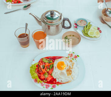 Omelett mit Gemüse, Thai Tee und Suppe auf dem Tisch Stockfoto