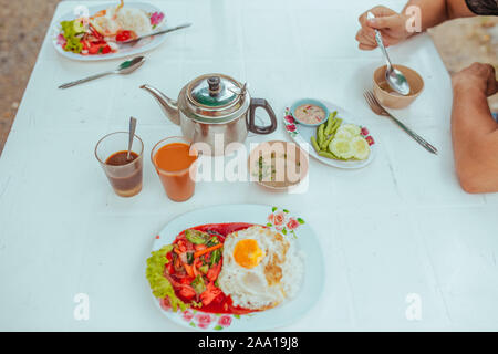 Omelett mit Gemüse, Thai Tee und Suppe auf dem Tisch Stockfoto